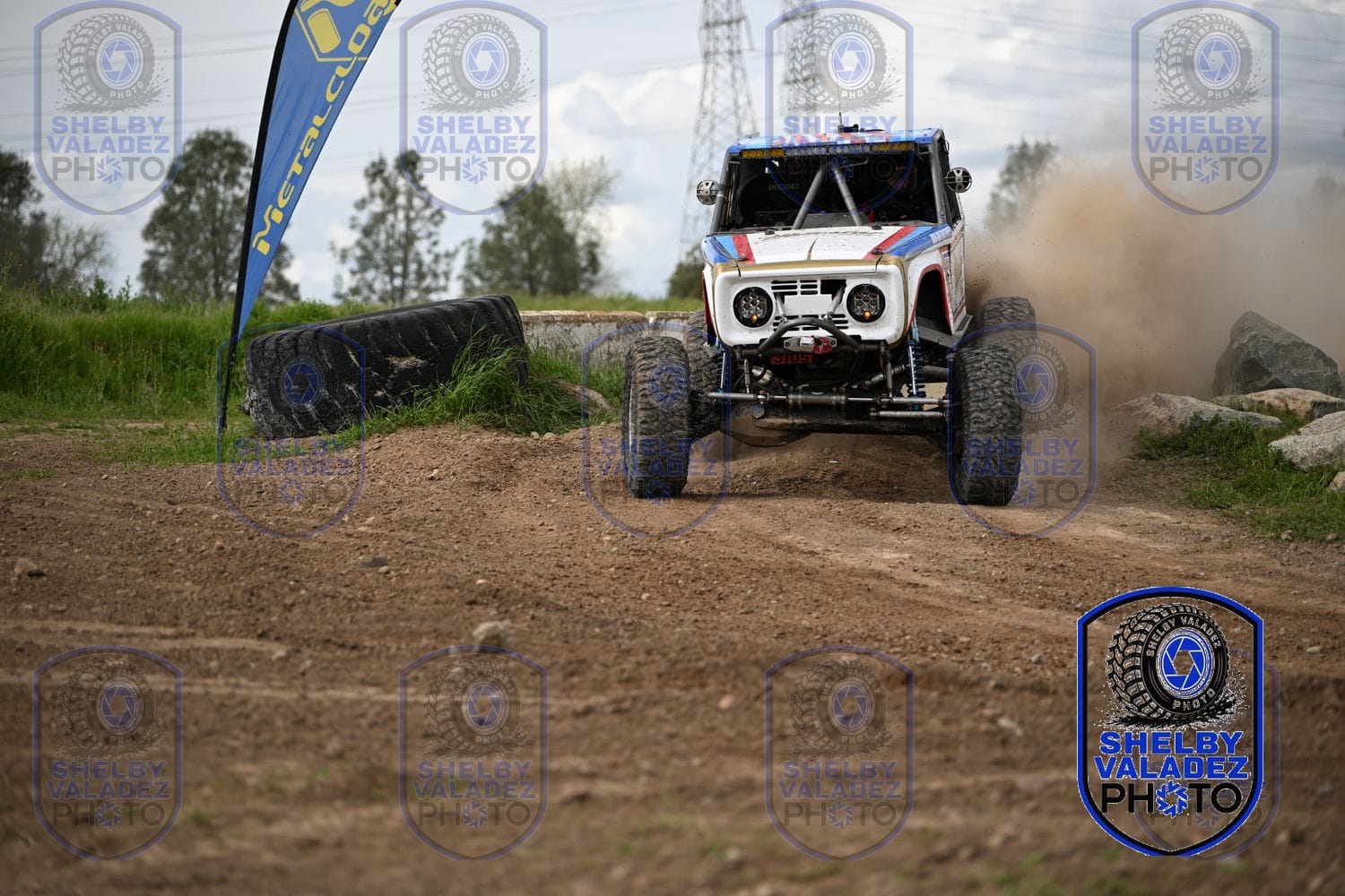 White and blue Bronco charging head-on down the dirt track