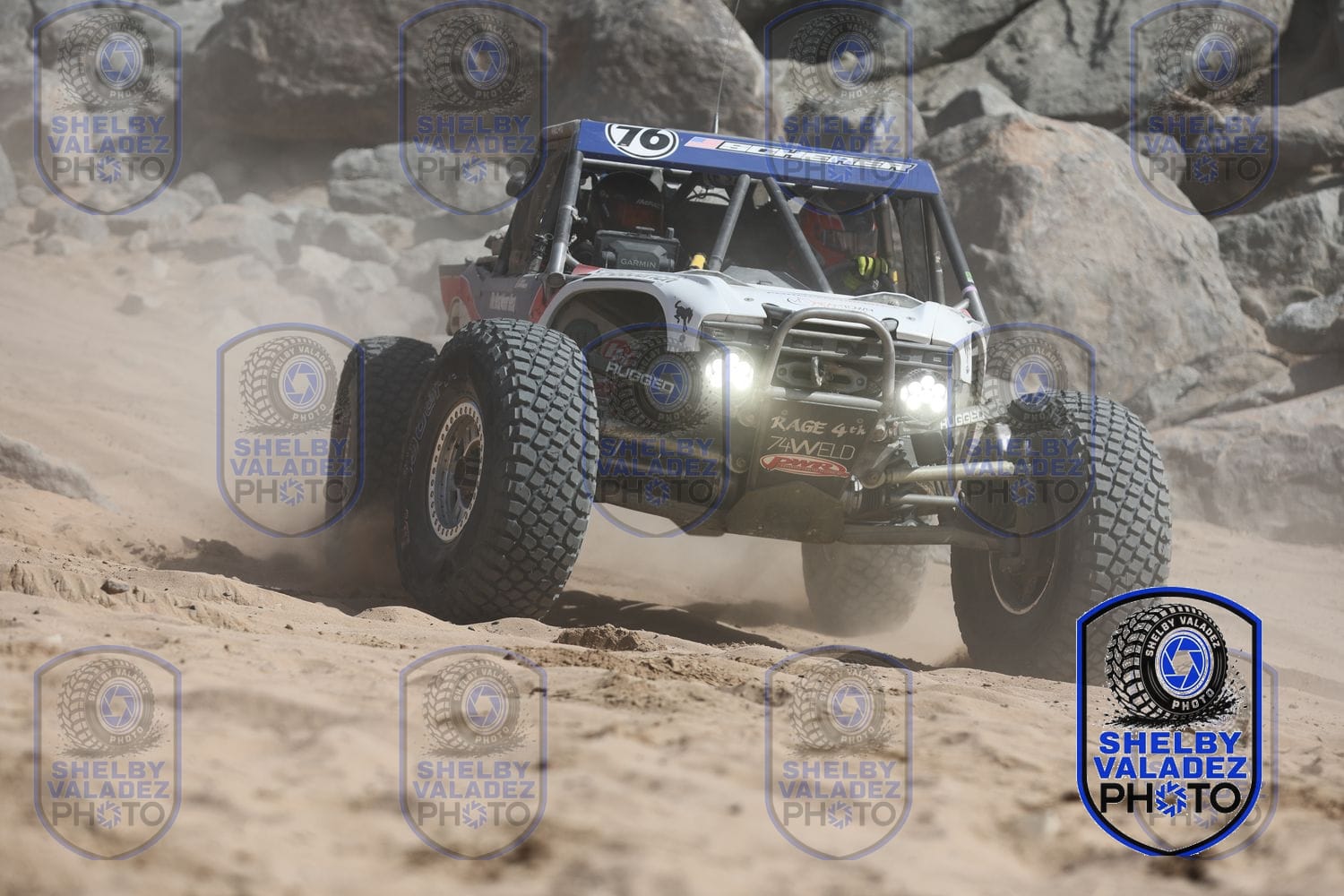 White Ultra4 car number 76 running the sand with lights blazing