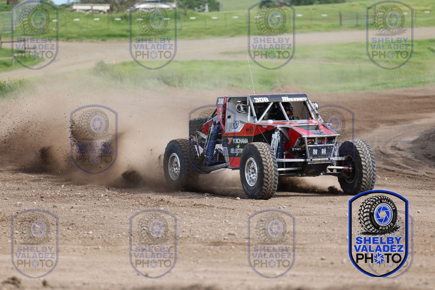 Red Ultra4 car throwing dirt as it powers down the track